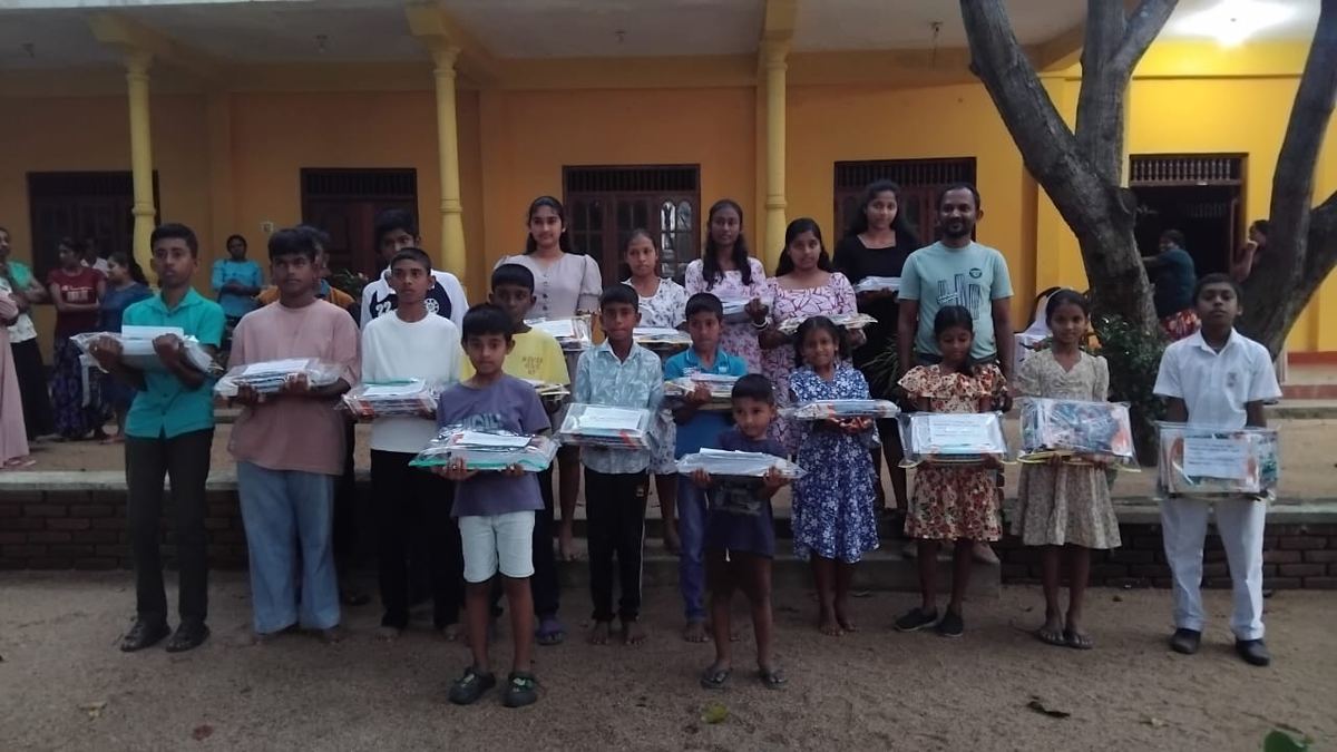 Children holding school supply packs after the Chinta Tours school donation